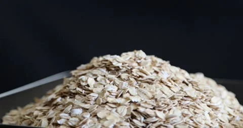 Dry oat flakes grains rotating on black background 1 Stock Footage 146986602