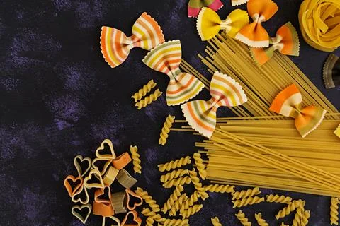 Dry pasta background. Different pasta on dark background. Flat lay. Top view. Stock Photos