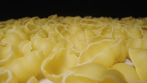 Dry pasta gnocchetti scattered on the table in an even layer, the camera slides  Stock Footage 231571080