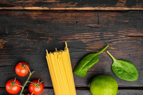 Dry pasta spaghetti, on old dark wooden table background, top view flat lay Stock Photos