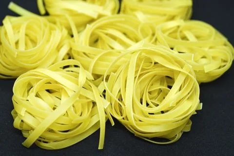 Dry paste on a black background. Wheat pasta. 스톡 사진