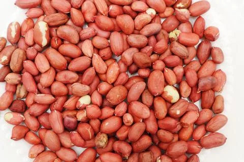 Dry peanuts lying on a white surface for viewing and tasting Stock Photos