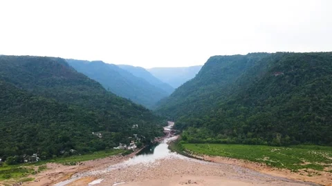 Dry piyain river through khasi hills with indigenous village houses and sandy Stock Footage 346886932