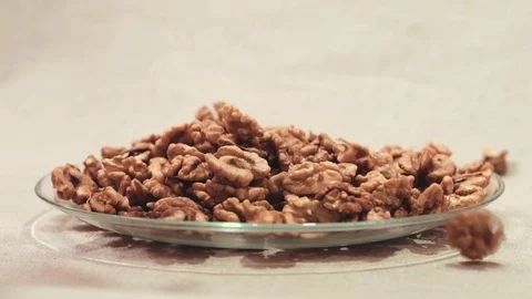 Dry raw walnut cores falling down into glass bowl Stock Footage 72115629
