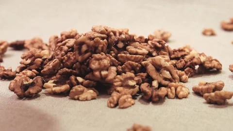 Dry raw walnut cores falling down on a linen fabric Stock Footage 72123284