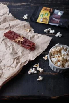 Dry red beef in package, jerky meat sticks tied with jute thread on paper Stock Photos