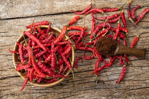Dry red chilli and chilli powder in wooden bowl. red dried pepper on a dark.. 스톡 사진