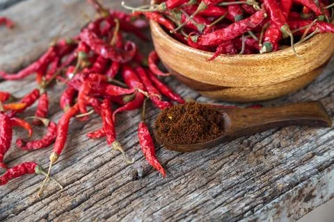 Dry red chilli and chilli powder in wooden bowl. red dried pepper on a dark.. Foto stock