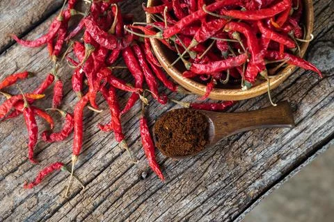Dry red chilli and chilli powder in wooden bowl. red dried pepper on a dark.. Stock Photos