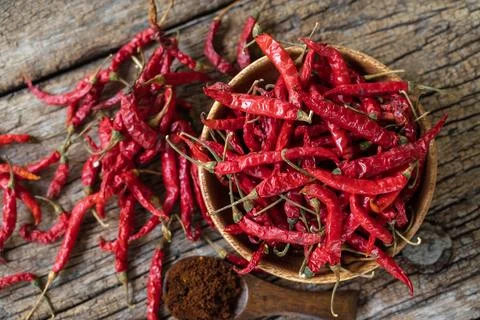 Dry red chilli and chilli powder in wooden bowl. red dried pepper on a dark.. Stock Photos