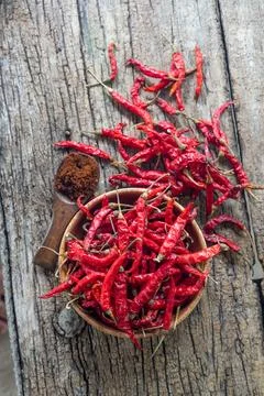 Dry red chilli and chilli powder in wooden bowl. red dried pepper on a dark.. Foto stock