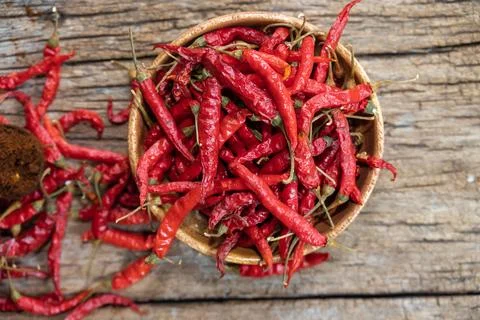 Dry red chilli and chilli powder in wooden bowl. red dried pepper on a dark.. Fotos de archivo