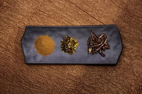 Dry red chilli, chilli flakes, red chilli powder on black platter isolated .. Stock Photos