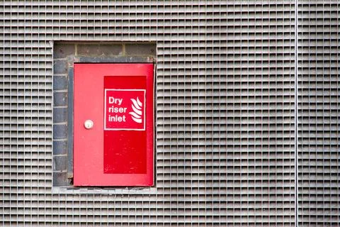Dry riser red inlet box and sign at wall Stock Photos