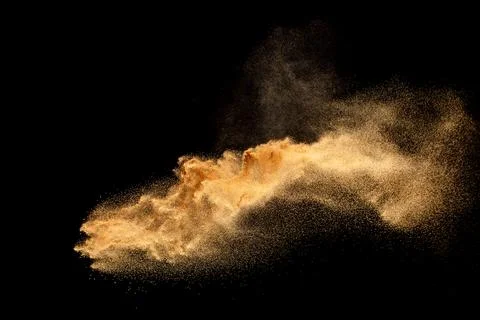 Dry river sand explosion. Brown colored sand splash against black background. Stock Photos