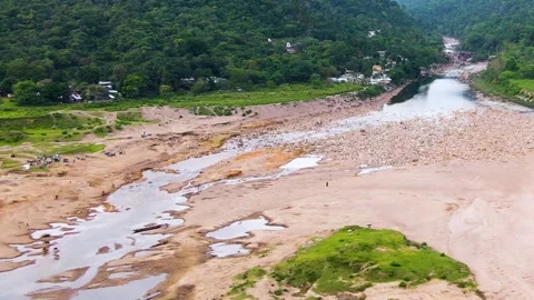 Dry riverbed with tribal settlement and forest Stock Footage 346415819