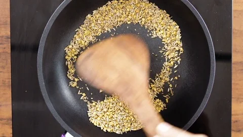 Dry Roasting Indian Spices using a Wooden Utensils-Top Angle Shot Stock Footage 80419504