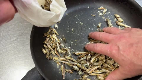 Dry roasting small dried sardines in a pan to make Japanese dashi stock Stock-Footage 337399858