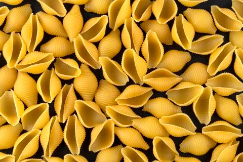 Dry shell pasta pattern on black background, top view Stock Photos
