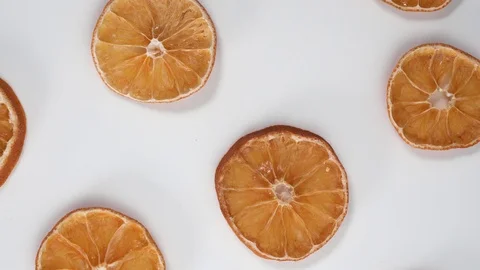 Dry slices orange on white table top down view rotate. Stock Footage 124418634