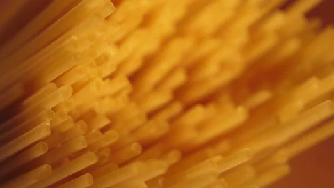 Dry spaghetti close up, macro view of pasta. Yellow food, carb diet, Italian coo Stock Footage 224290373