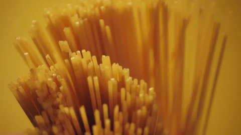 Dry spaghetti close up, macro view of pasta. Yellow food, carb diet, Italian coo Stock Footage 224290646