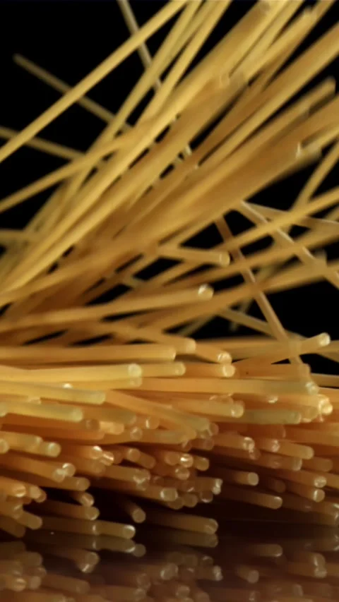 Dry spaghetti falling on a black background. Filmed on a high-speed camera at Stock Footage 335359142