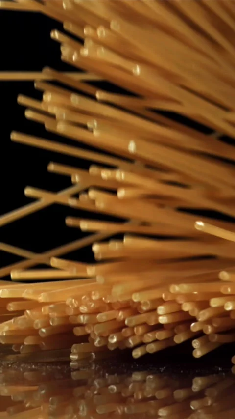 Dry spaghetti falling on a black background. Filmed on a high-speed camera at Stock Footage 335359920