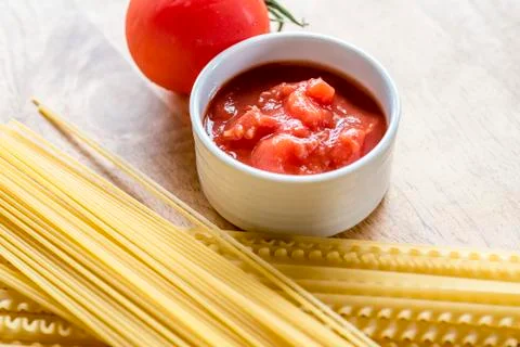 Dry spaghetti, fresh tomato and tomato sauce, closeup. Stock Photos