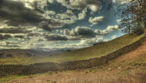 Dry stone wall and clouds Stock Photos