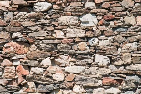 Dry stone wall made of irregular shaped stones Stock Photos