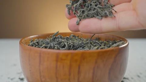 Dry tea leaves are shown by touching them with your fingers. Stock Footage 295230756