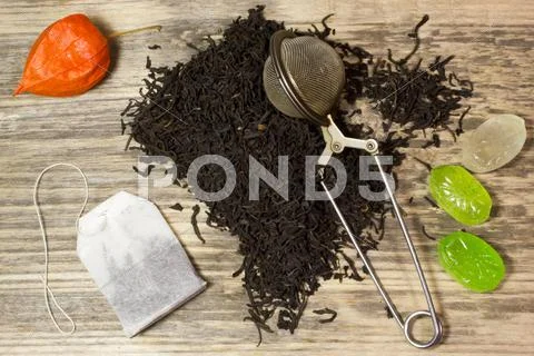 Dry Tea Leaves For Black Tea And Paper Tea Bag On Wooden Background
