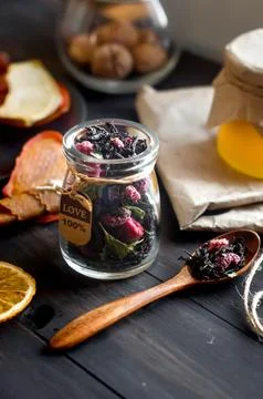Dry tea with raspberry in jar and spoon on dark wooden table Stock Photos