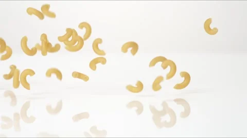 Dry uncooked Elbow Macaroni Mac And Cheese Bouncing Slow Motion White Tabletop Stock Footage 335460926