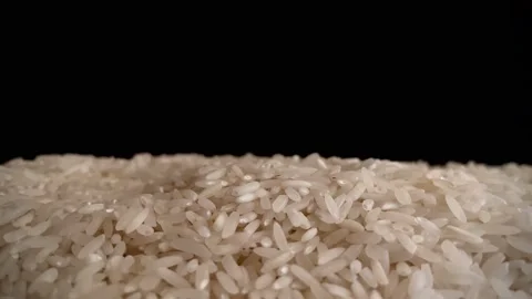 Dry uncooked rice is poured from top to bottom Stock Footage