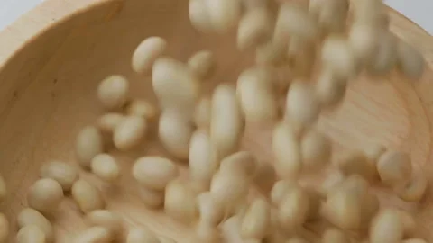 Dry white beans seeds falling down into wooden bowl Video stock 142676903