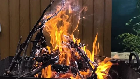 Dry wood burns brightly inside metal brazier during outdoor barbecue cooking Stock Footage 346046491