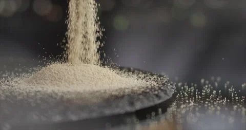 Dry yeast falling on a black surface Stock Footage 199022946