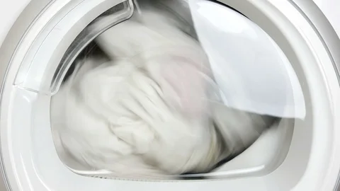 Dryer machine drying rotating swirl spin closeup porthole 4k Stock Footage 105930073