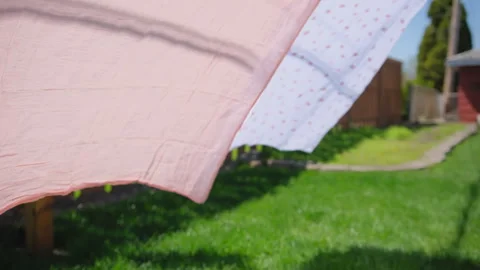 Drying bed sheets outdoor which develops in the wind in summer time. Close up Vidéo 274863814