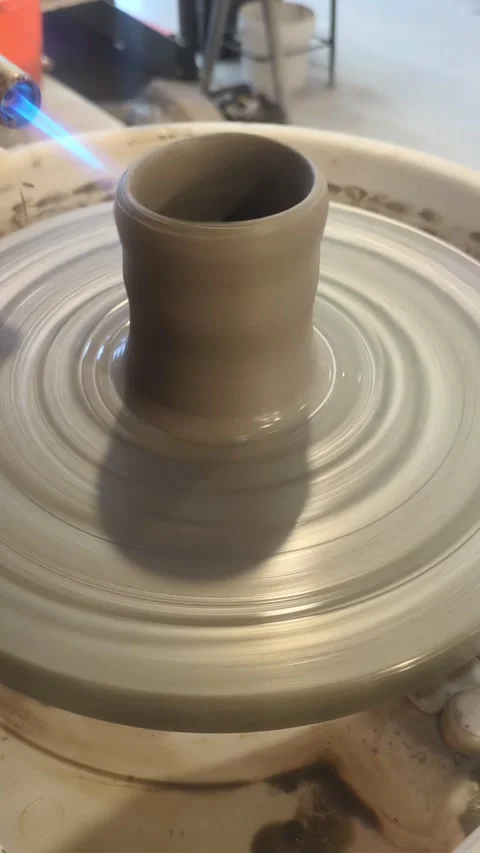 Drying a clay cup with blow torch on pottery wheel Stock Footage 304753231