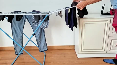 Drying Clean Clothes on a Folding Rack Indoors at Home After Washing Vídeos de archivo 347688054
