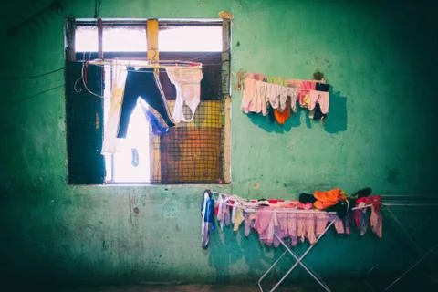 Drying clothes near a window of a decayed occupied building. Stock Photos