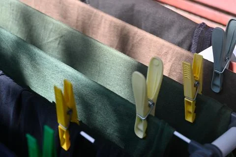 Drying clothes secured with clothespins on a drying rack Stock Photos