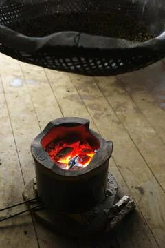 Drying coffee beans over the fire in a small localized pit Stock Photos