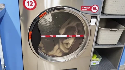 Drying cycle of woolen plaid. Drum rotation of professional dryer machine. Self Stock Footage 255594556