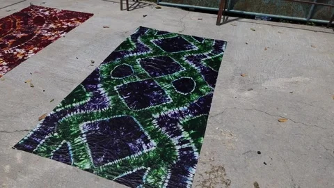 Drying fabrics with batik patterns and motifs on the ground Vídeo Stock 304848683