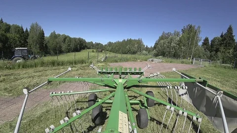 Drying hay by turning with a rotor tractor rake Stock Footage 111928366