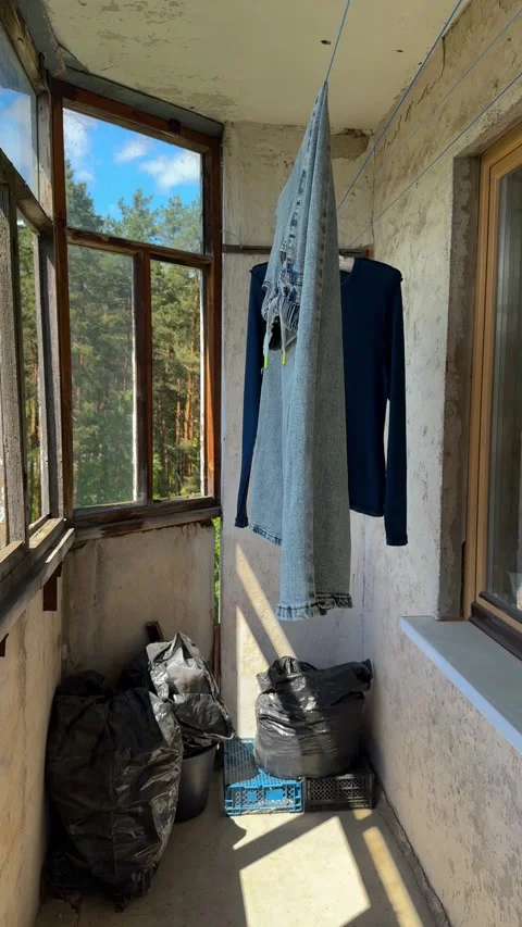Drying laundry on an old apartment balcony with an open window  Stock Footage 337434582